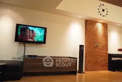 Modern living room with exposed brick wall and mounted TV