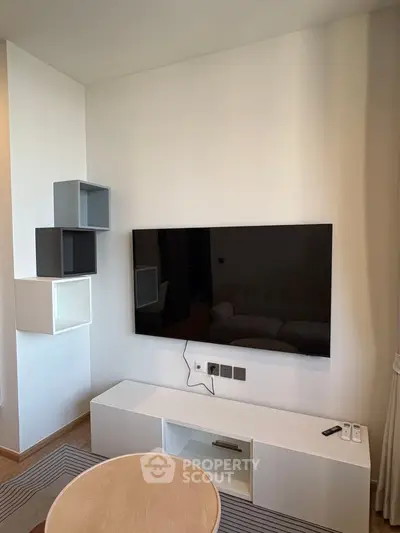 Modern living room with wall-mounted TV and stylish shelving