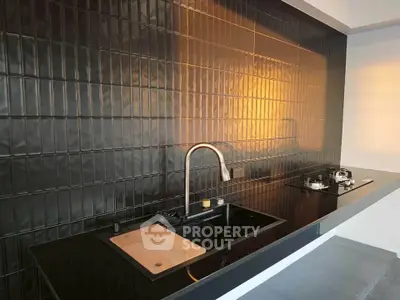 Modern kitchen with sleek black backsplash and gas stove