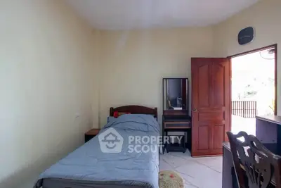 Cozy bedroom with single bed and wooden furniture, perfect for a peaceful retreat.