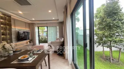 Spacious living room with garden view, modern decor, and large sliding glass doors.