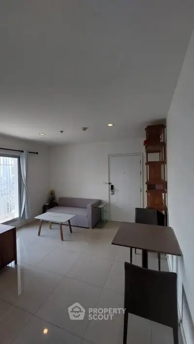 Spacious modern living room with sleek furniture and large windows offering natural light.