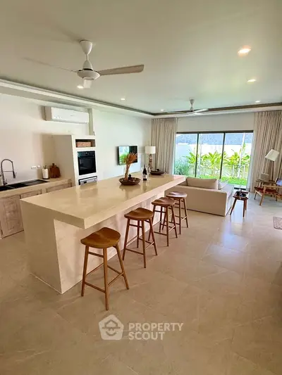 Spacious open-plan living room with modern kitchen and garden view, perfect for entertaining.