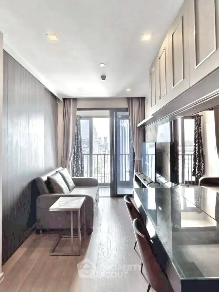 Modern living room with city view, sleek furniture, and floor-to-ceiling windows in a high-rise apartment.