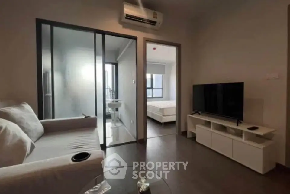 Modern apartment interior with cozy living room and bedroom, featuring sleek furniture and natural light.