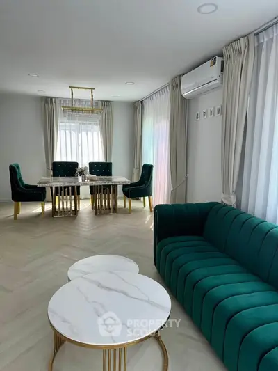 Elegant living room with green velvet sofa and stylish dining area