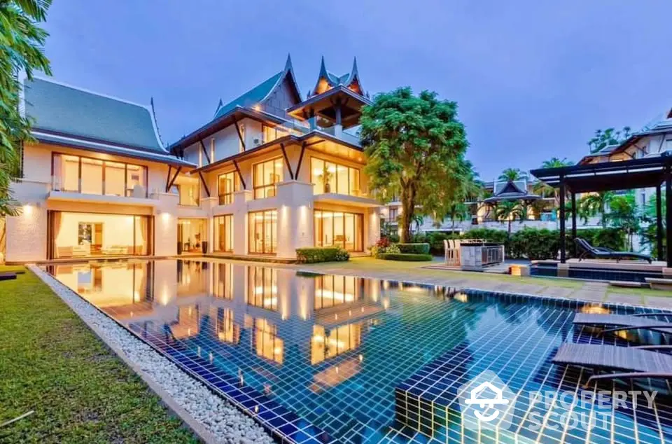 Luxurious Thai-style villa with stunning pool and lush garden at twilight