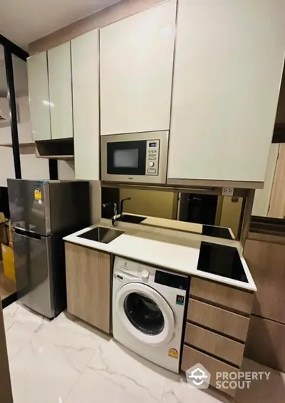 Modern kitchen with sleek appliances and integrated washing machine