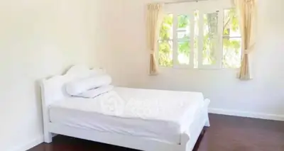 Bright and airy bedroom with large window and elegant white bed frame.