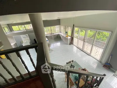 Spacious open-plan living area with large windows and garden view, perfect for modern family living.
