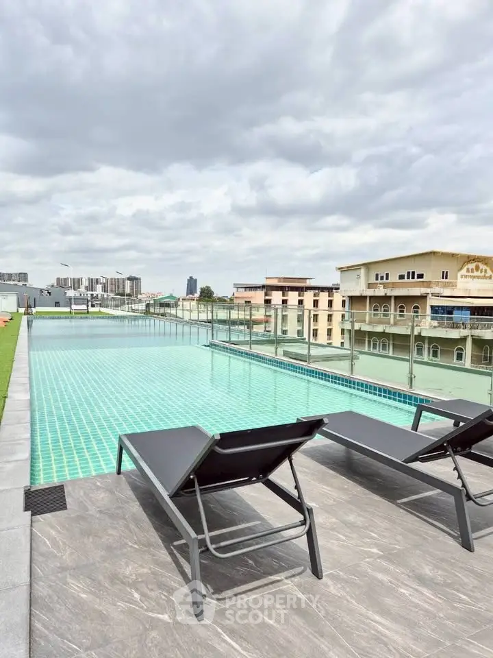 Luxurious rooftop pool with city views and modern lounge chairs, perfect for relaxation and leisure.