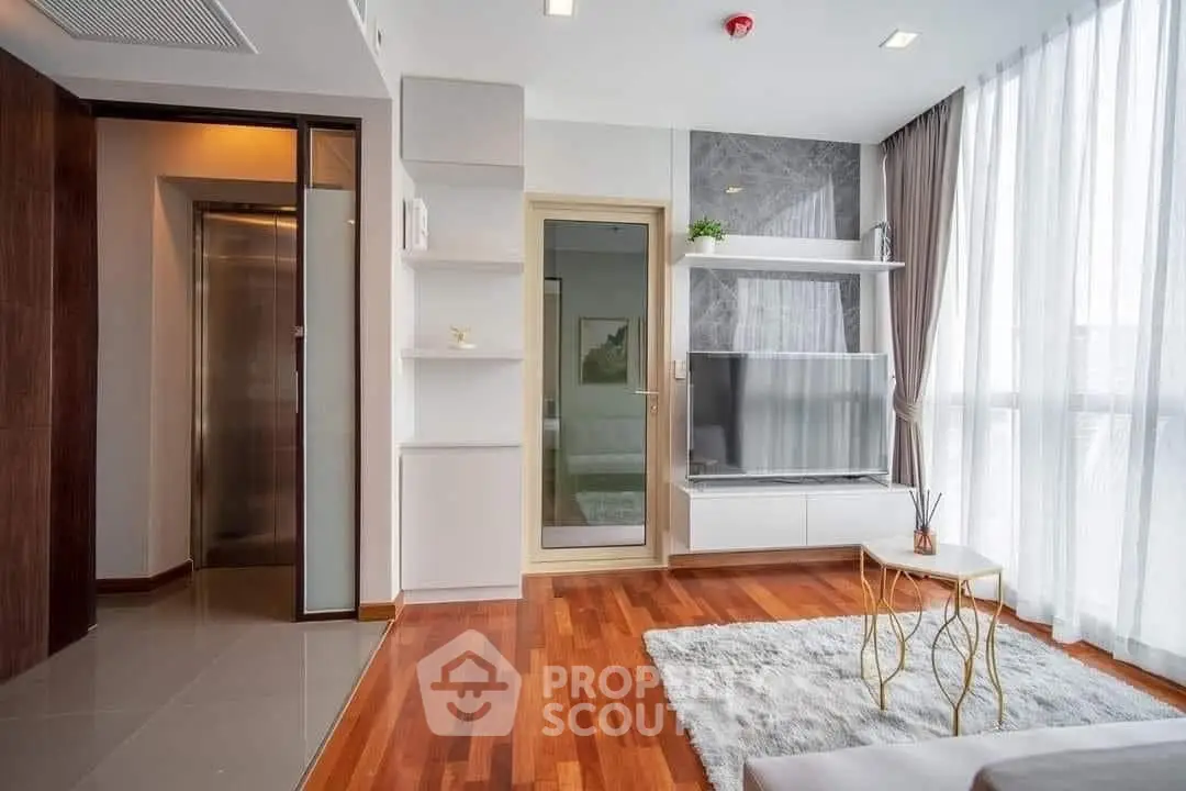 Modern living room with hardwood floors, large windows, and stylish decor in a contemporary apartment.
