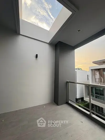 Modern balcony with skylight and glass railing offering a serene view