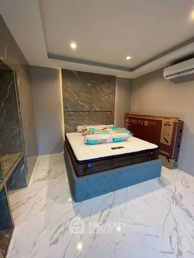 Luxurious bedroom with marble flooring and modern decor featuring a new LG UHD TV.