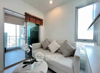 Modern living room with cozy sofa and balcony view in a bright apartment.