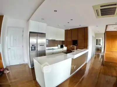 Modern kitchen with sleek design, featuring stainless steel appliances and wooden accents.