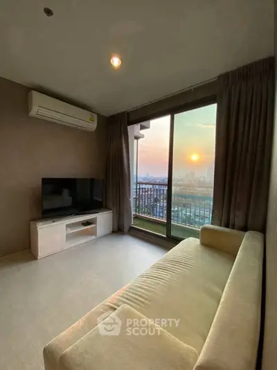 Spacious living room with stunning sunset view from large balcony window.