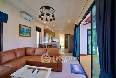 Spacious living room with modern decor and open kitchen layout in a luxurious home.