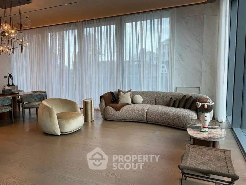 Luxurious modern living room with elegant furniture and floor-to-ceiling windows.