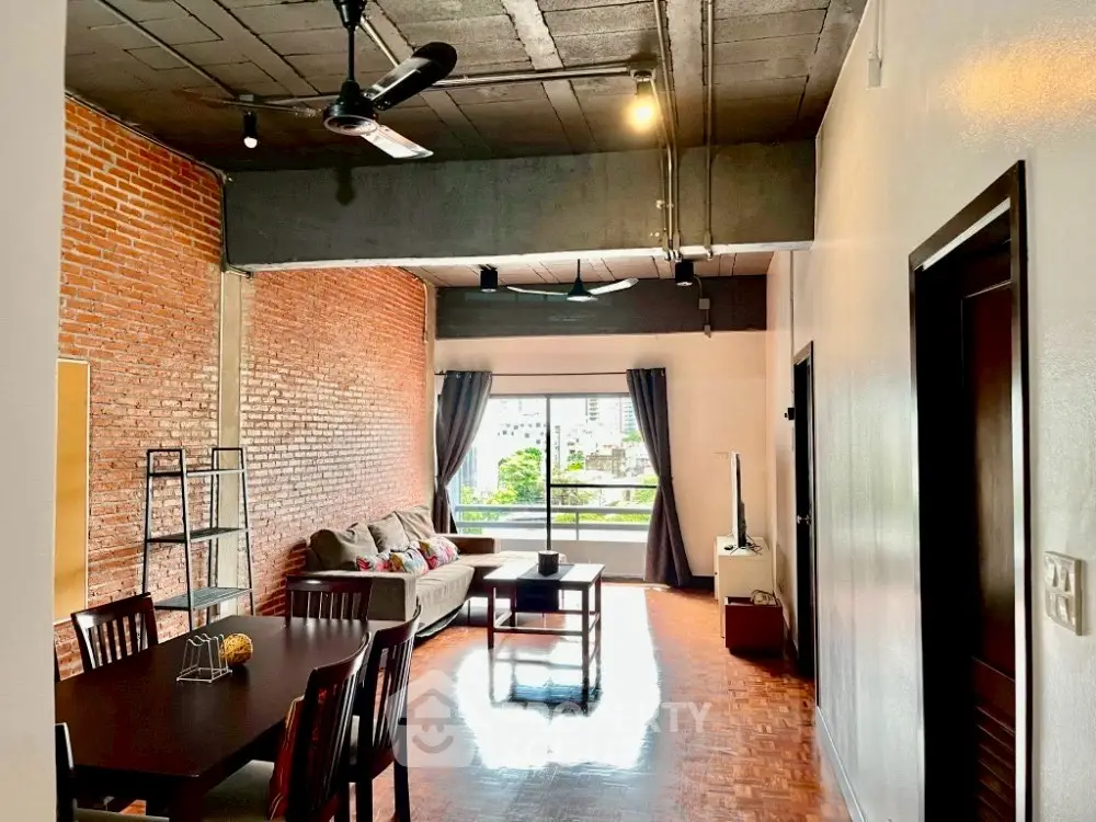 Spacious loft-style living room with exposed brick wall and modern furnishings.