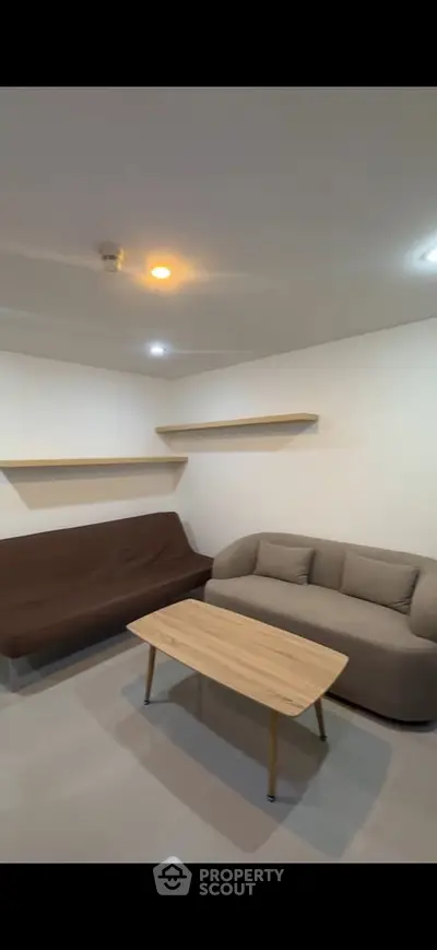 Modern living room with sleek furniture and minimalist design, featuring a cozy sofa and stylish coffee table.