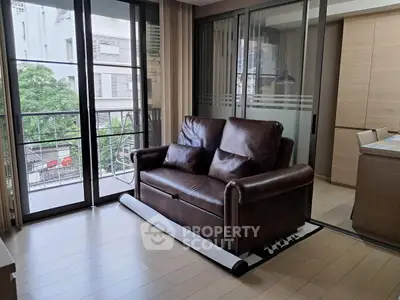 Modern living room with leather sofa and large windows overlooking urban view