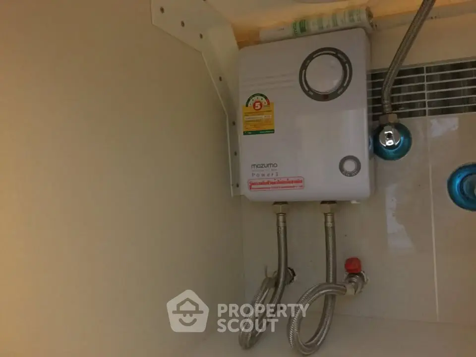 Compact water heater installed in a modern bathroom corner, showcasing efficient space utilization.