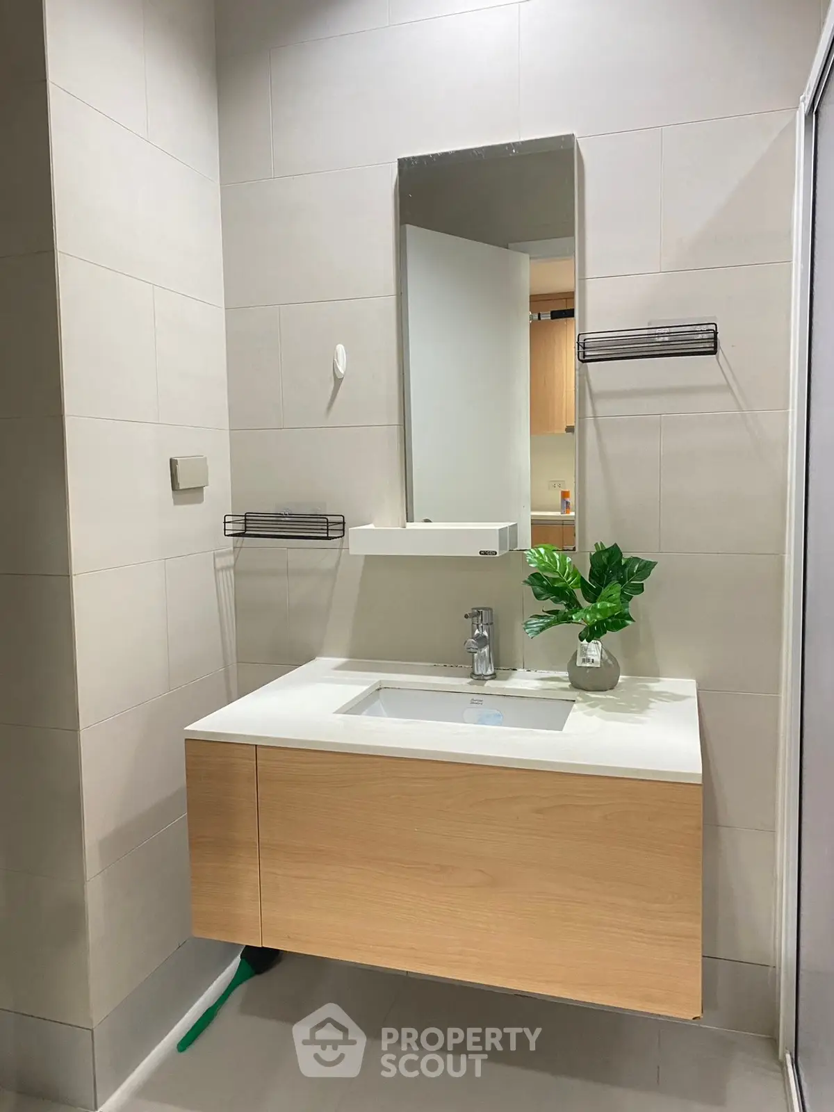 Modern bathroom with sleek vanity and mirror, featuring minimalist design and neutral tones.