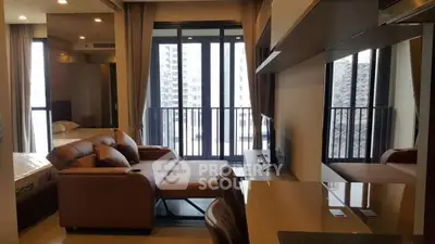 Modern living room with large windows and city view, featuring a stylish sofa and sleek interior design.