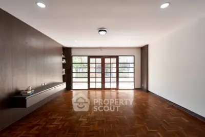 Spacious living room with elegant wooden flooring and large windows for natural light.