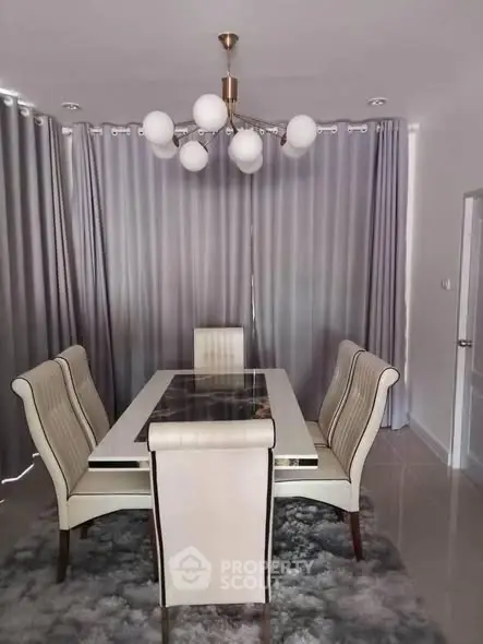 Elegant dining room with modern chandelier and stylish chairs, perfect for sophisticated gatherings.