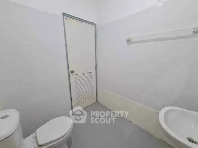 Minimalist bathroom with white tiles and basic fixtures