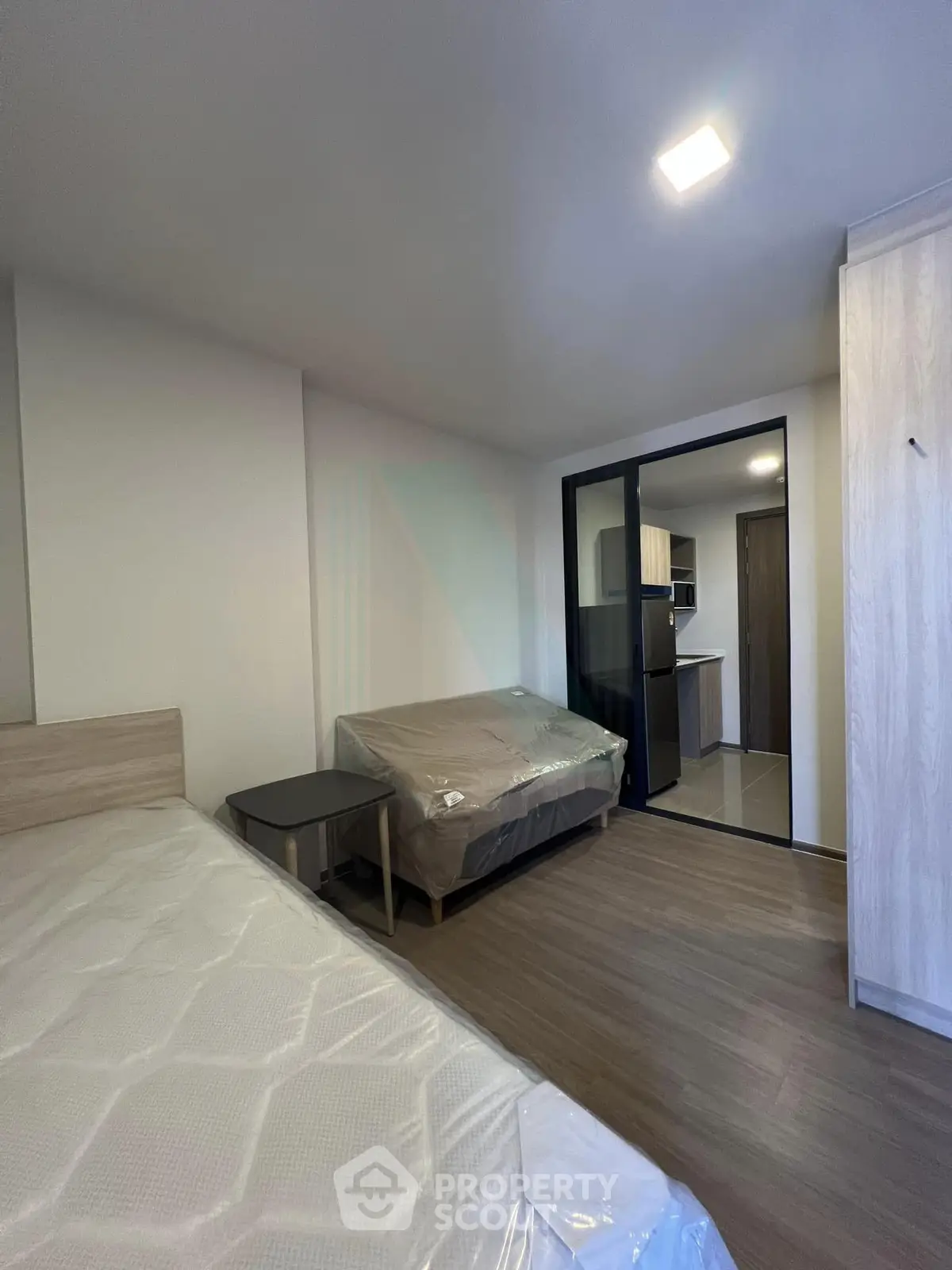 Modern studio apartment with cozy furnishings and sleek kitchen area.