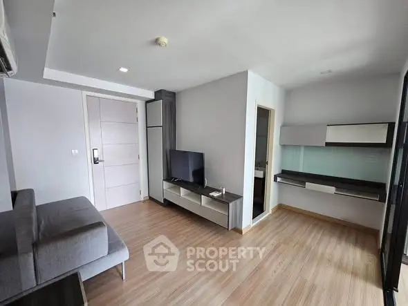 Modern living room with sleek furniture and wooden flooring in a contemporary apartment.