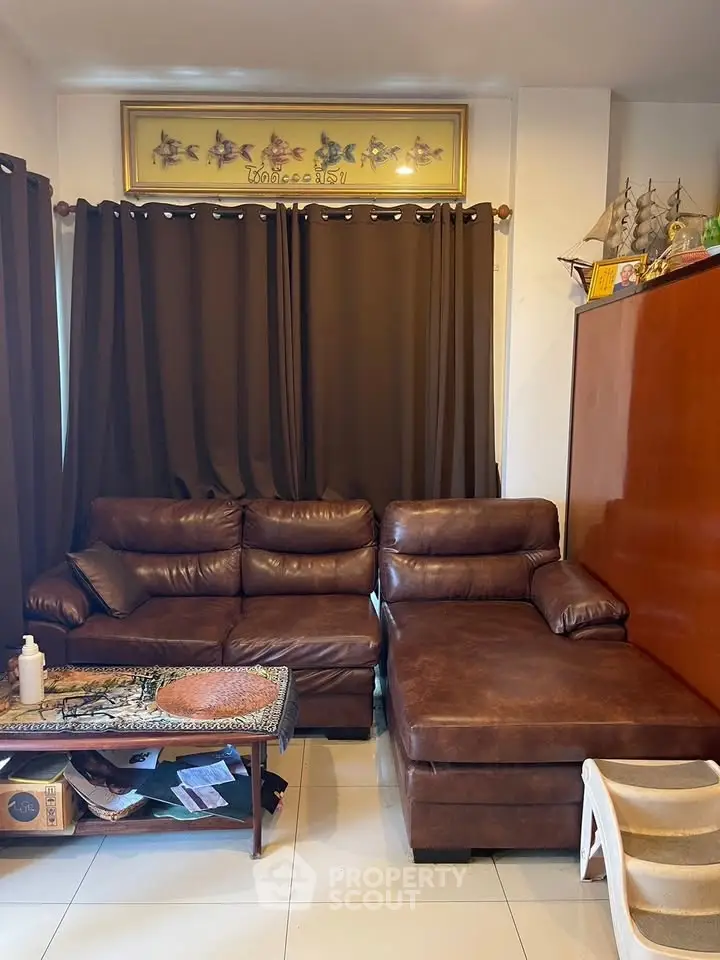 Cozy living room with brown leather sectional sofa and decorative accents.