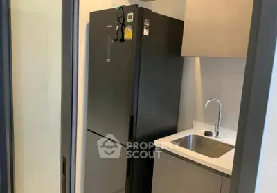 Modern kitchen with sleek black fridge and compact sink area
