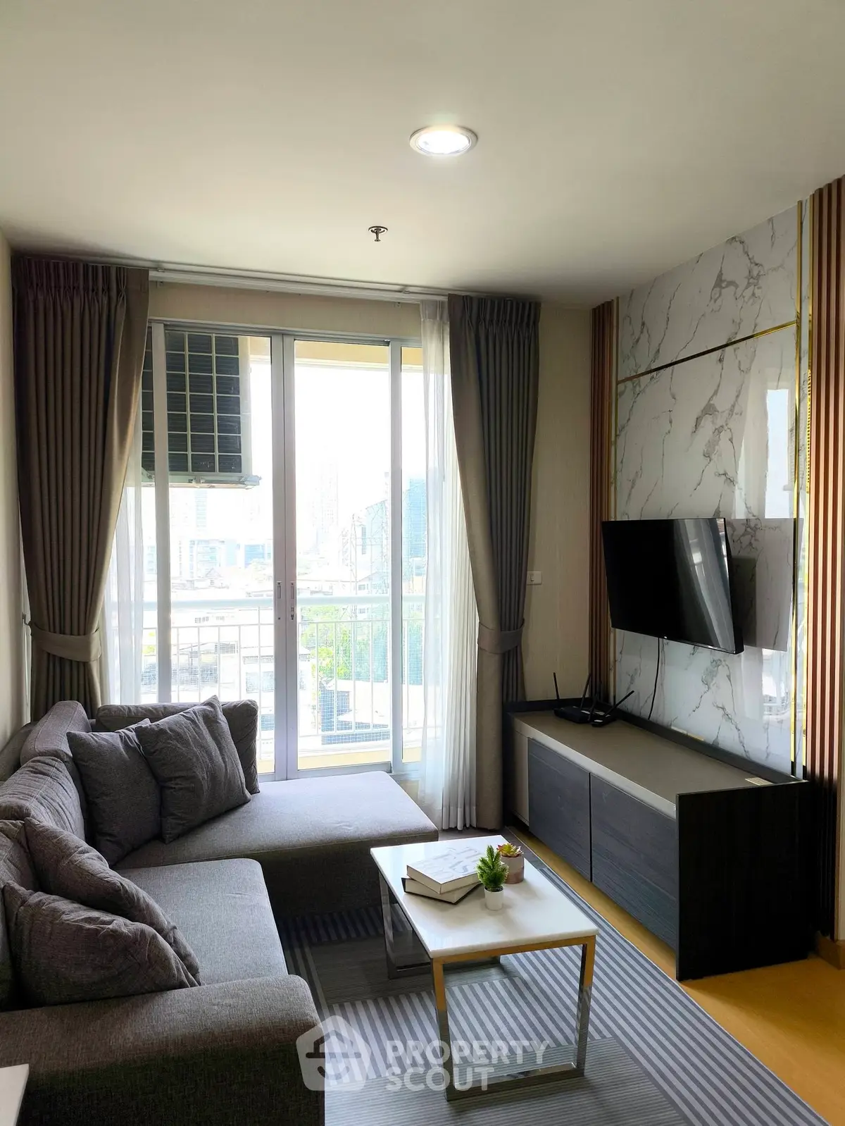 Modern living room with stylish decor and city view from balcony.