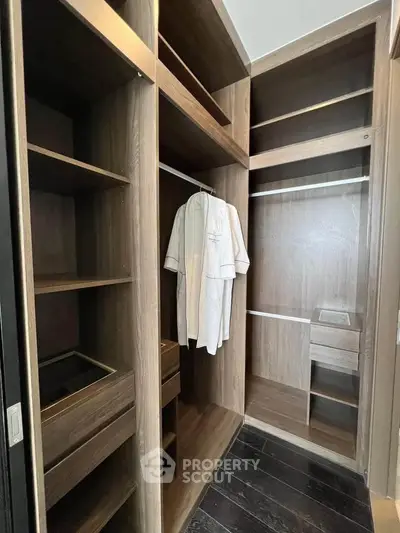 Spacious walk-in closet with wooden shelves and hanging space in modern home.