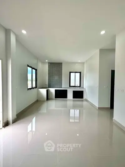 Spacious modern living room with large windows and sleek tile flooring