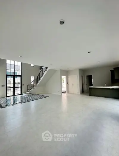 Spacious modern living room with open kitchen and elegant staircase
