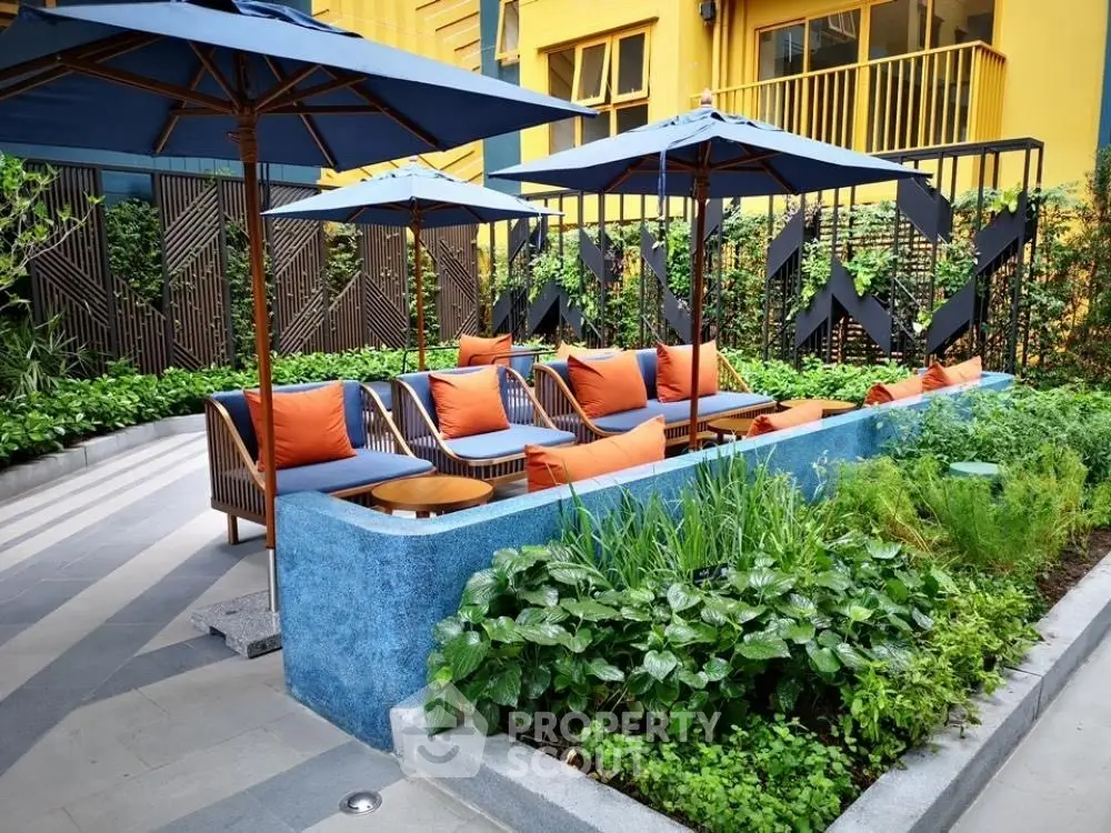 Chic outdoor seating area with vibrant cushions and lush greenery in modern apartment complex.