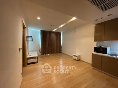 Spacious modern living room with wooden flooring and integrated kitchen area.