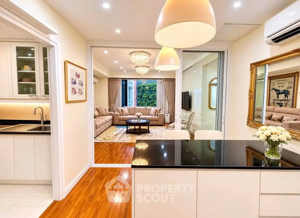 Luxurious open-plan kitchen and living room with elegant decor and modern lighting.