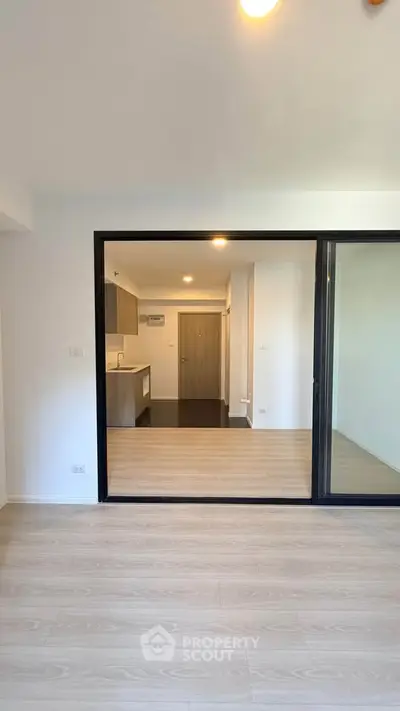Modern open-plan living room with sliding glass doors and stylish kitchen area.