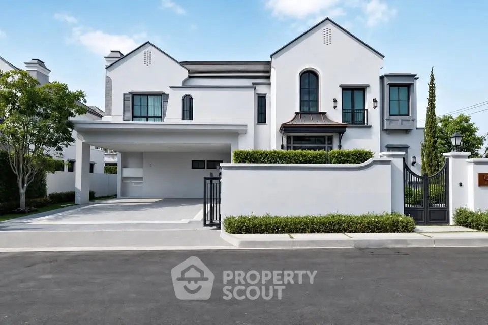 Stunning modern white house with gated entrance and spacious driveway in a serene neighborhood.