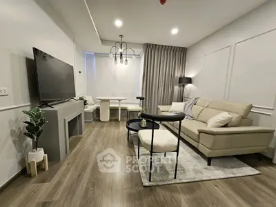 Modern living room with stylish furniture and large TV, perfect for relaxation and entertainment.