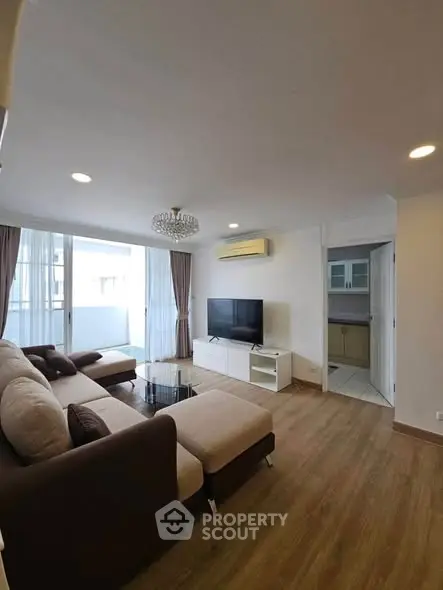 Spacious living room with modern decor and large windows in a stylish apartment.