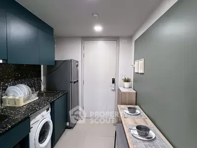 Modern kitchen with sleek cabinets, washing machine, and dining setup