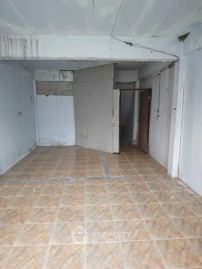 Spacious unfinished room with tiled floor and potential for customization.