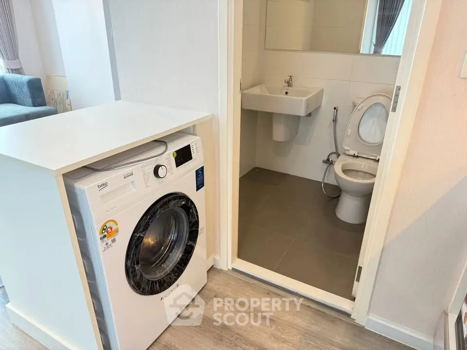 Compact bathroom with washing machine in modern apartment